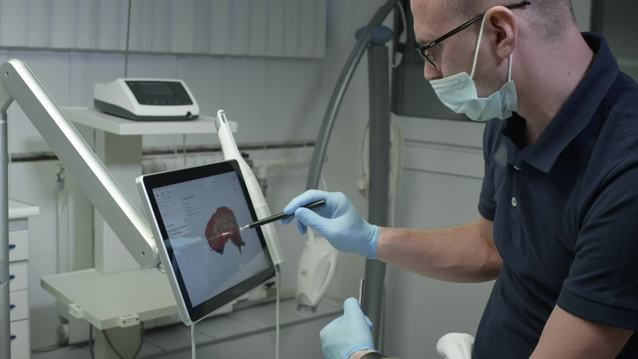 医生检查颌骨的三维模型。一名牙医正在检查监视器上的牙齿数字图像。现代医学和牙科技术视频下载