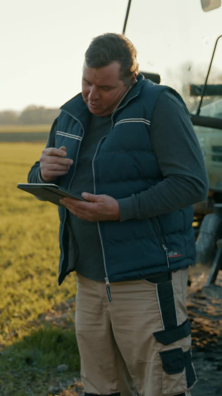 成年农民在田间使用数字平板电脑时打电话视频素材