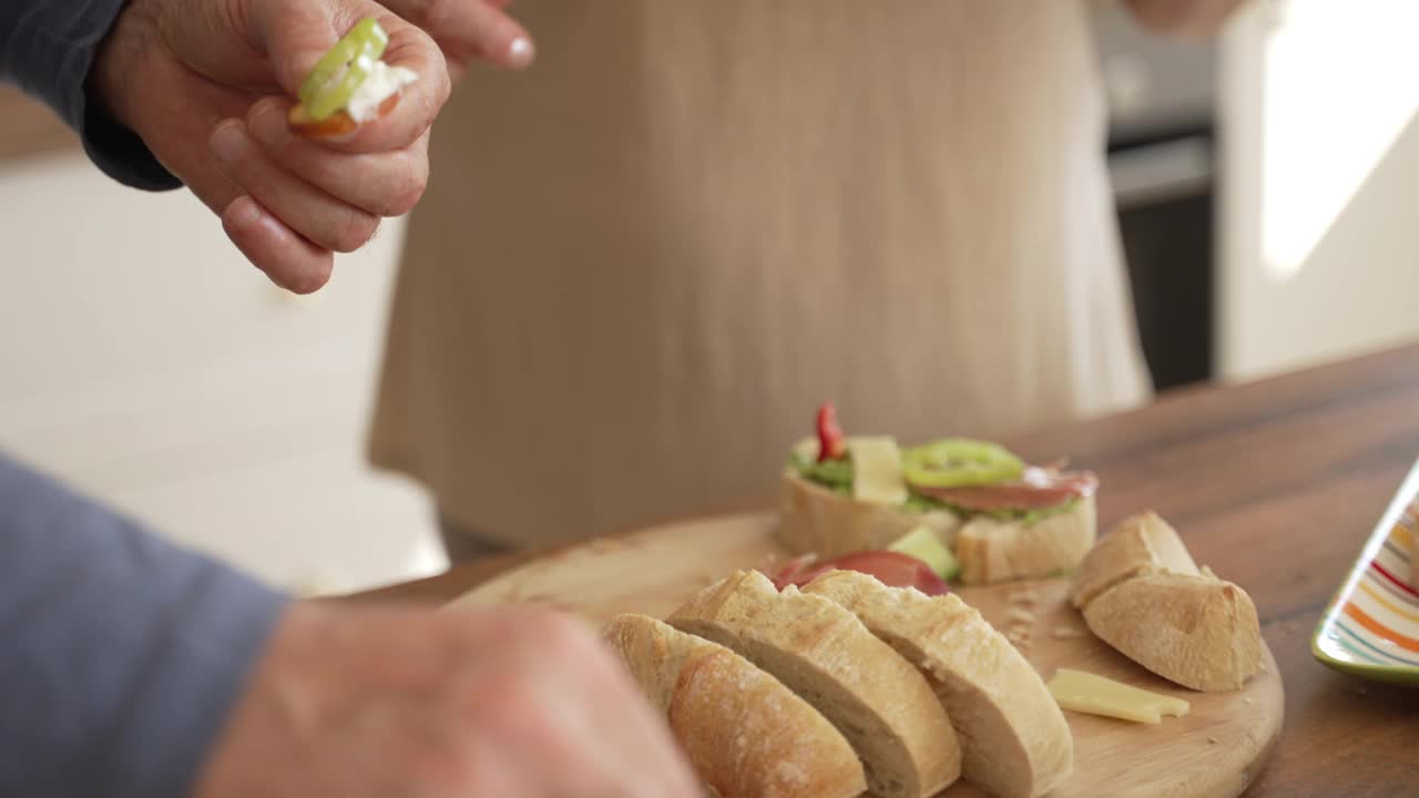 在家庭早午餐的时候，慈眉善目的祖母正在把烤面包放在五颜六色的盘子里视频下载