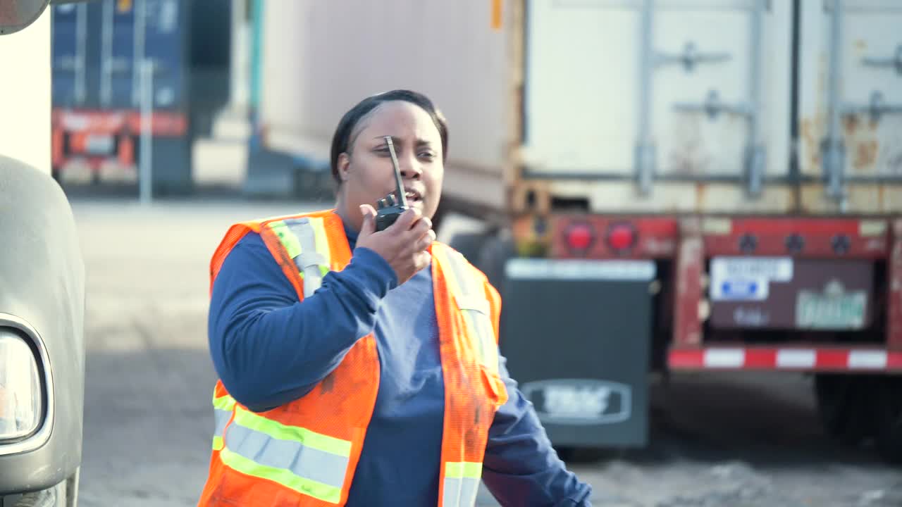 女卡车司机在货运中心用对讲机说话视频素材