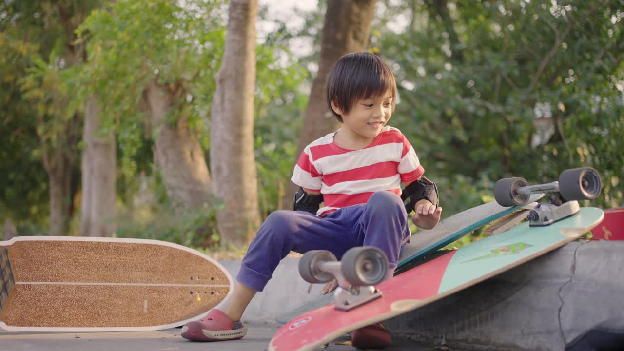 亚洲男孩玩滑板车轮与喜悦。视频素材