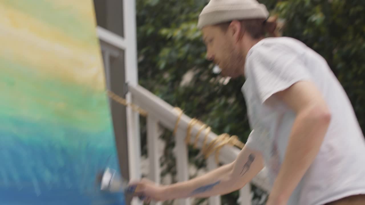 画家快速移动他们的画笔在一个巨大的画布上，而工作在一幅壁画外面视频下载