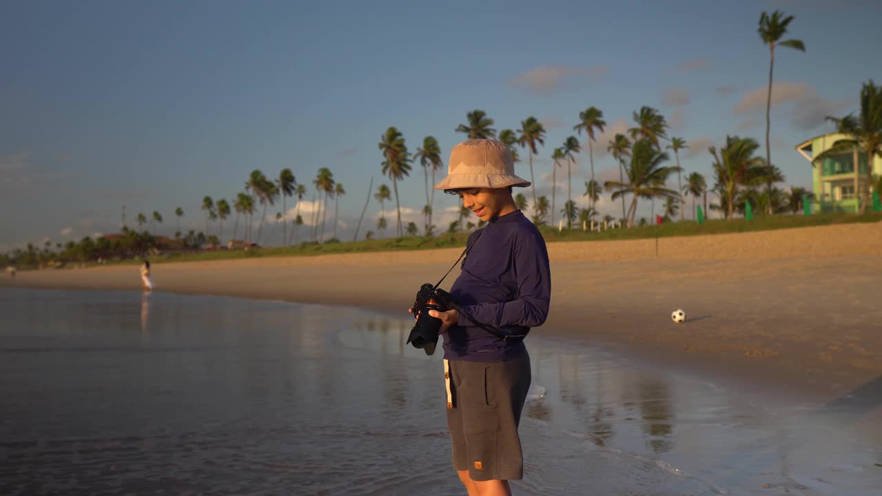 日出时在海滩上拍照的男孩视频下载