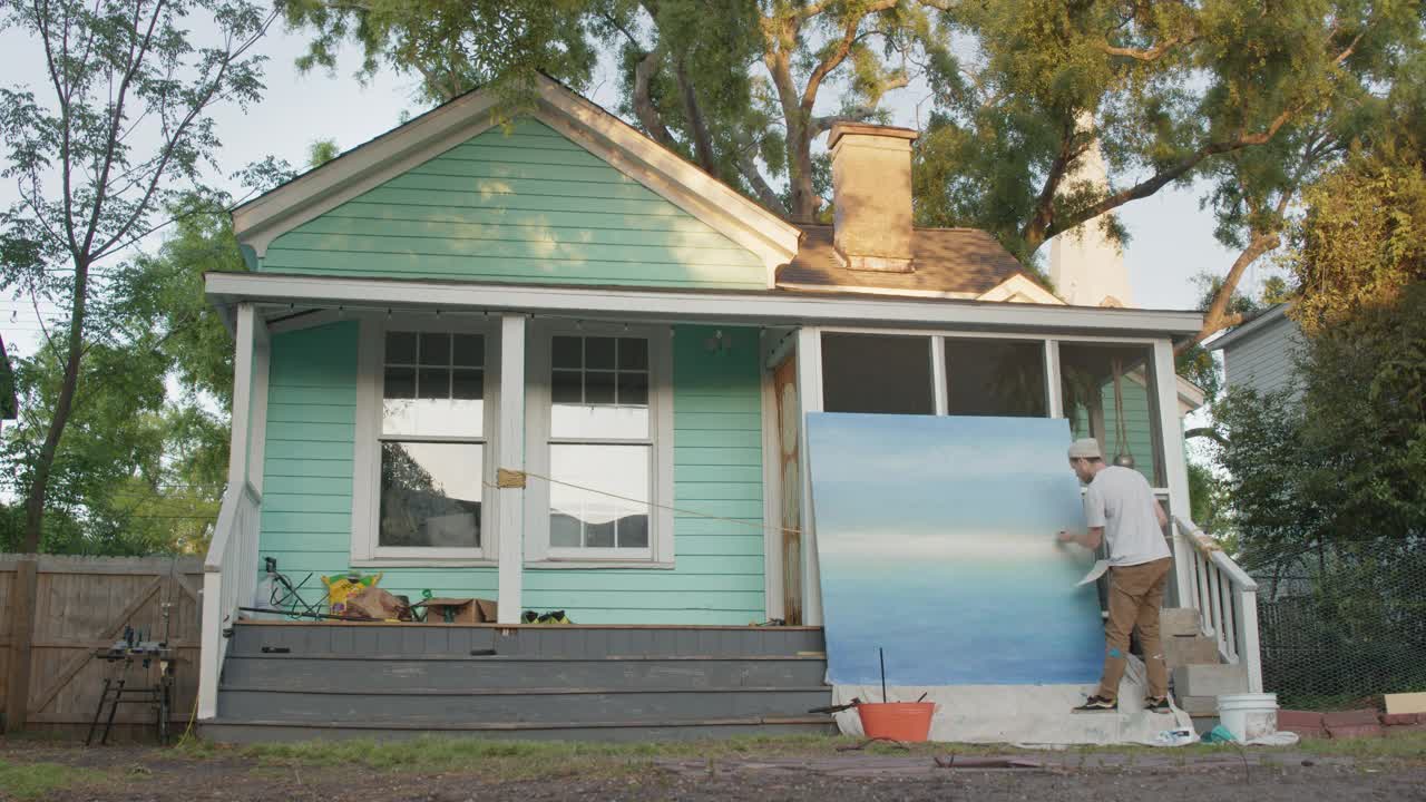 勤劳的画家在他们房子外面的大壁画上工作视频下载