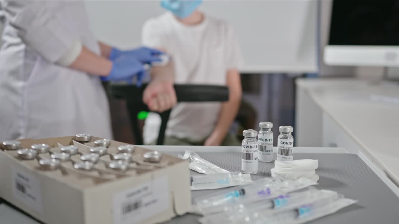 在接种室为一名十几岁的男孩注射疫苗。冠状病毒感染期间人群接种疫苗的概念视频素材