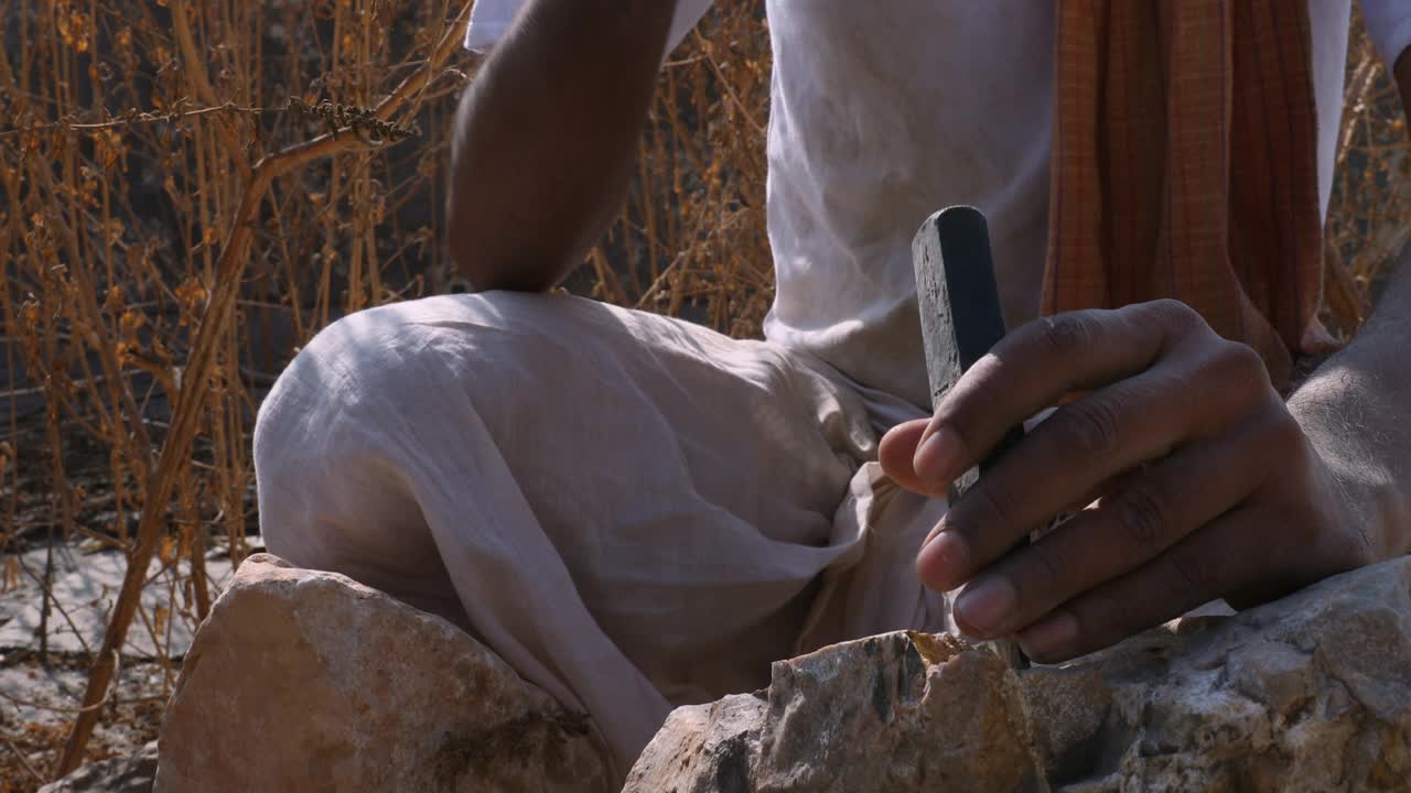 男子的手用锤子和凿子凿石头的中等镜头视频下载