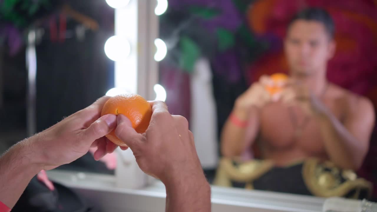 男舞者在镜子前撕扯橙色视频素材