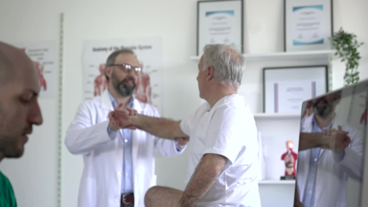 资深病人和理疗师在医生的办公室讨论他的康复视频素材