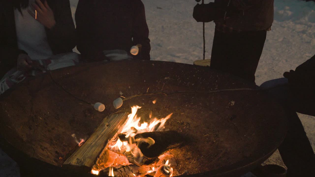 篝火上烤棉花糖，背景是雪视频下载