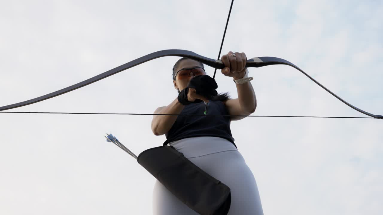 特写迷人的亚洲女性练习射箭在靶场。视频下载