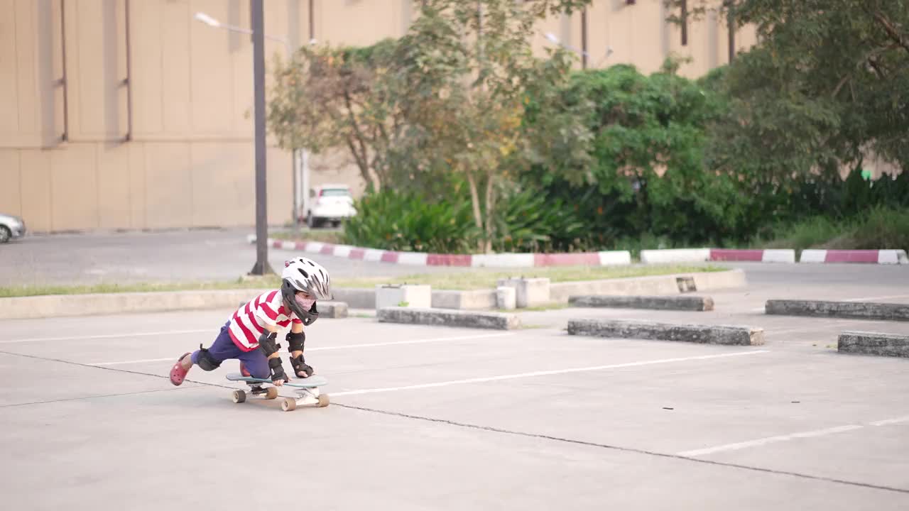亚洲小男孩在停车场玩冲浪滑板。视频下载