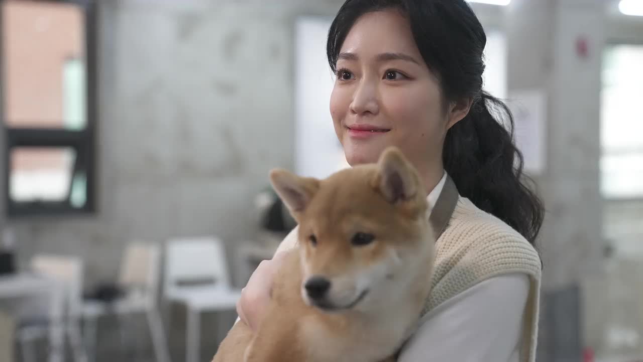 狗咖啡馆-员工拥抱小狗并微笑视频下载