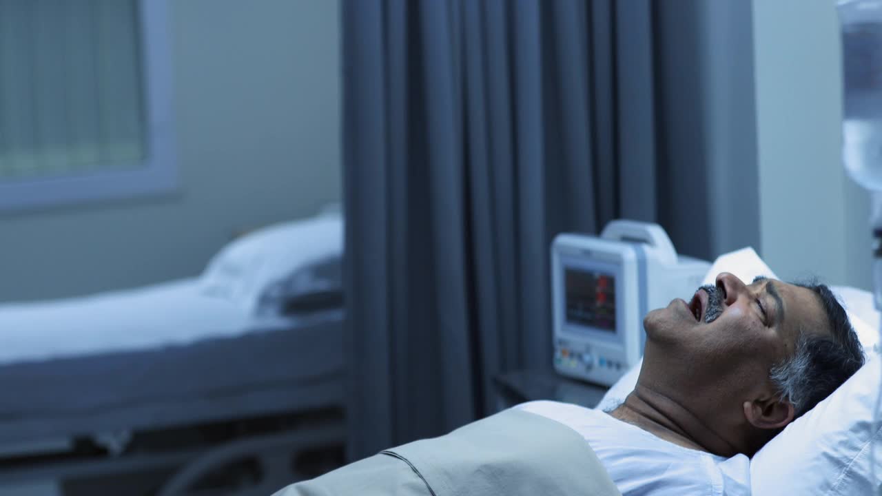 中等拍摄的生病的成熟男子哭泣，看着医院的空床视频素材