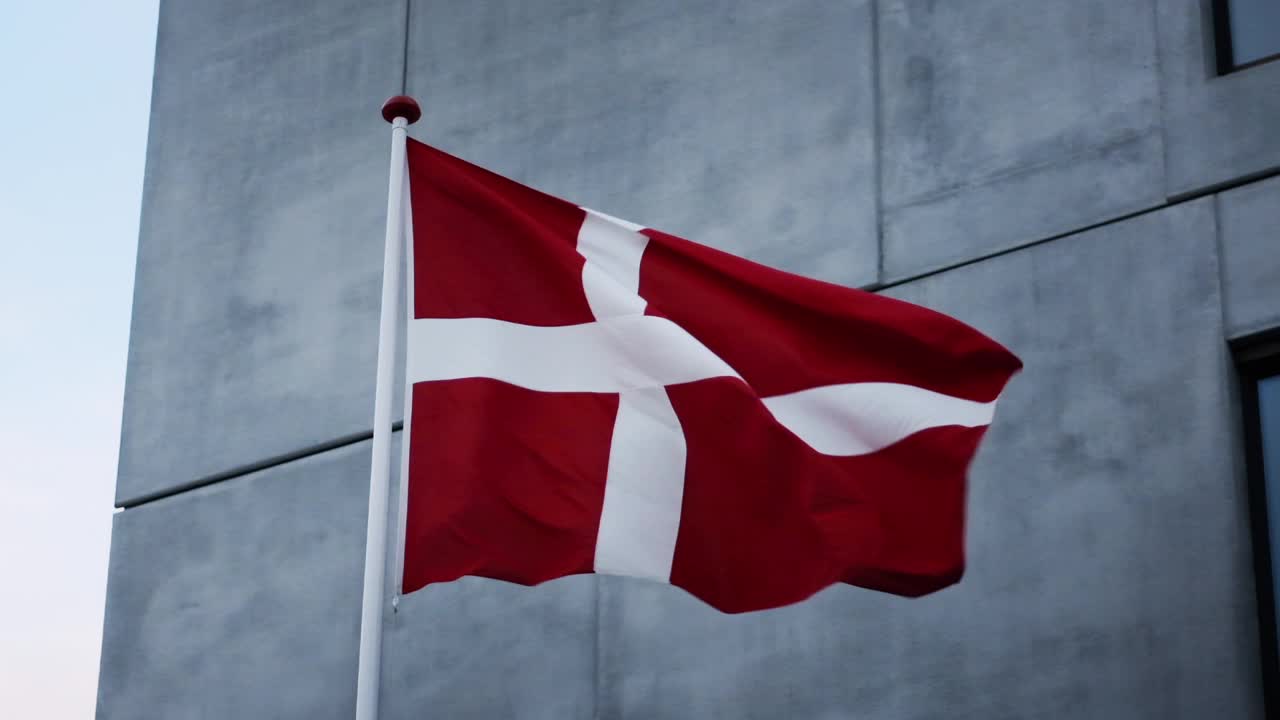灰色大楼外丹麦国旗随风飘扬视频下载