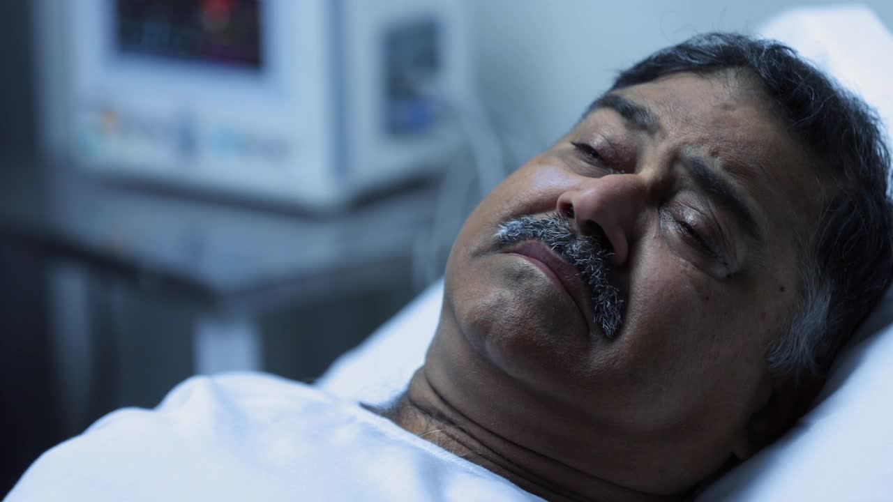 一个成年男子躺在医院病床上哭泣的特写视频素材