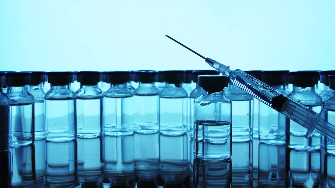 疫苗瓶和注射器注射。在安瓶药。实验室液体样品用玻璃小瓶。视频素材