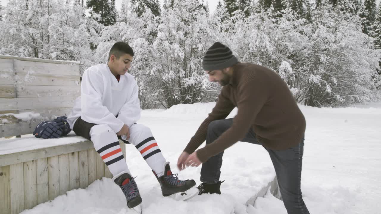 爸爸帮儿子系鞋带，其他儿子在后面溜冰视频下载