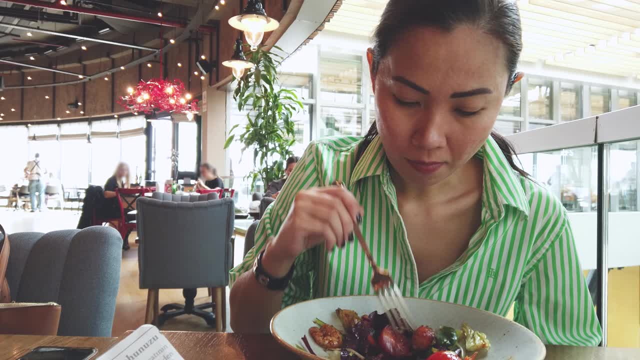 一个女人独自在餐厅吃沙拉视频素材