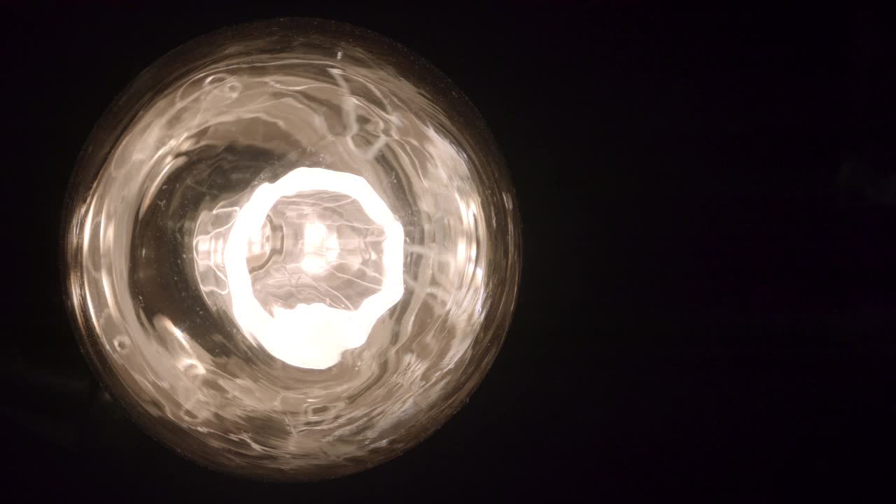 在黑暗的房间里关掉的灯泡的正面视图视频下载