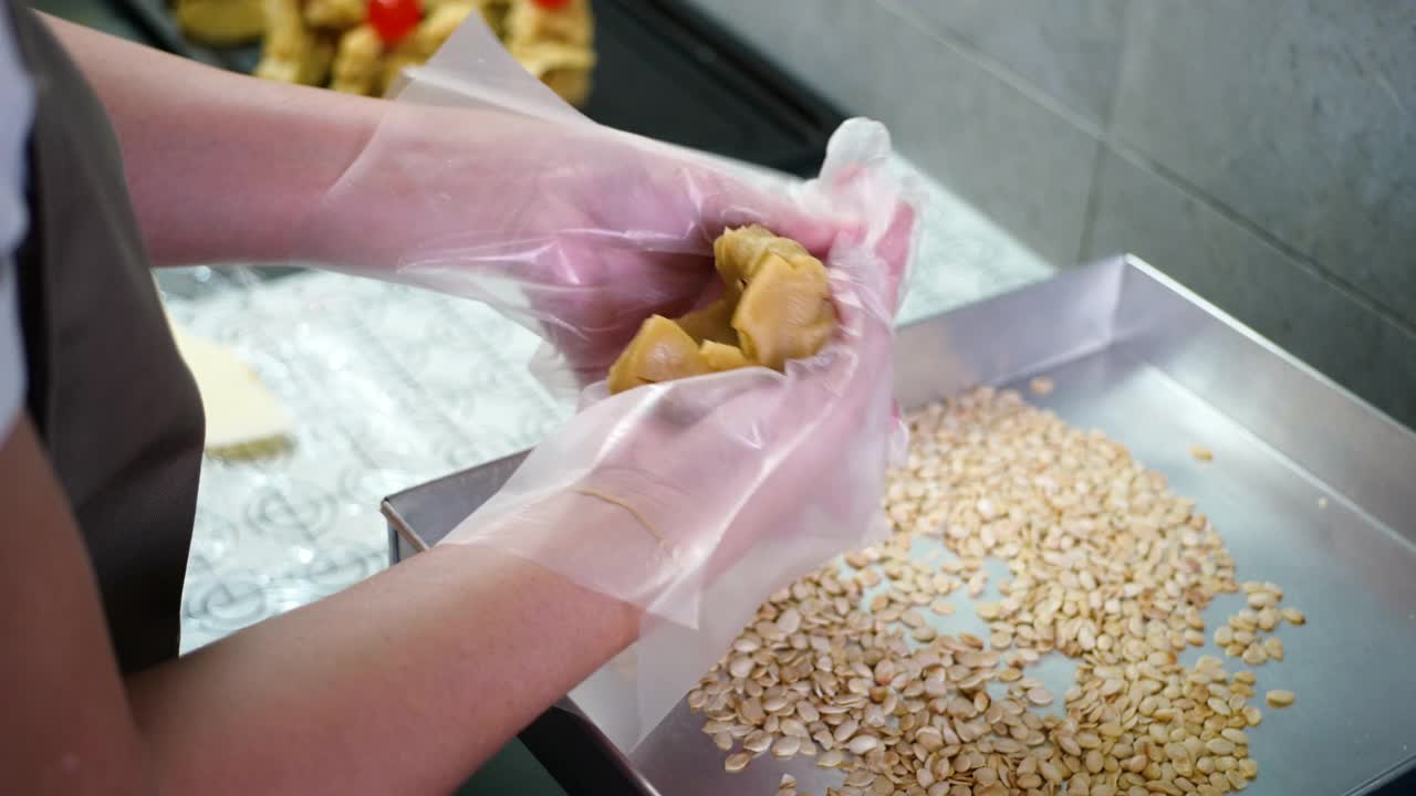 亚洲妇女在厨房制作月饼面团视频下载