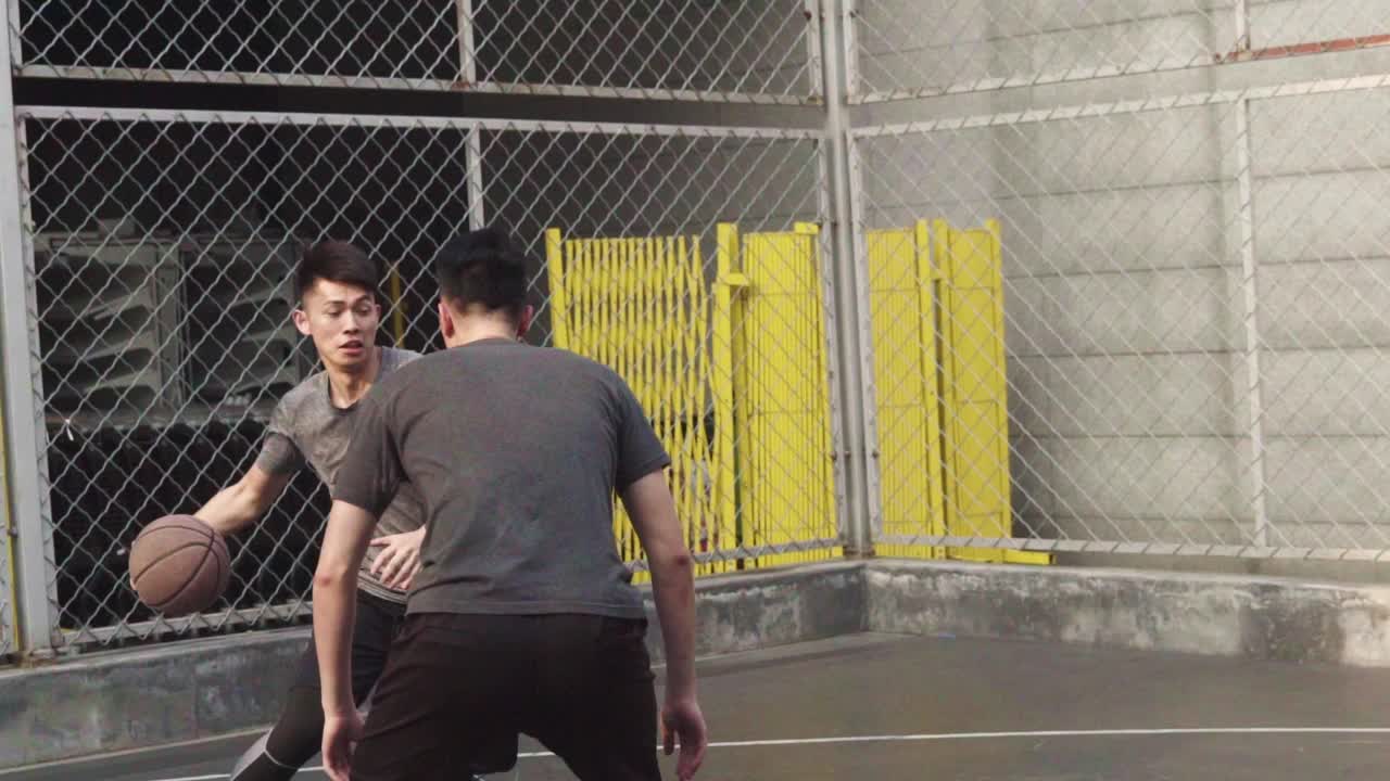 年轻的亚洲男子在户外打篮球视频素材