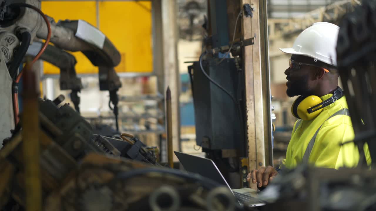 4K黑人非洲工程师在工业机器人上工作视频素材