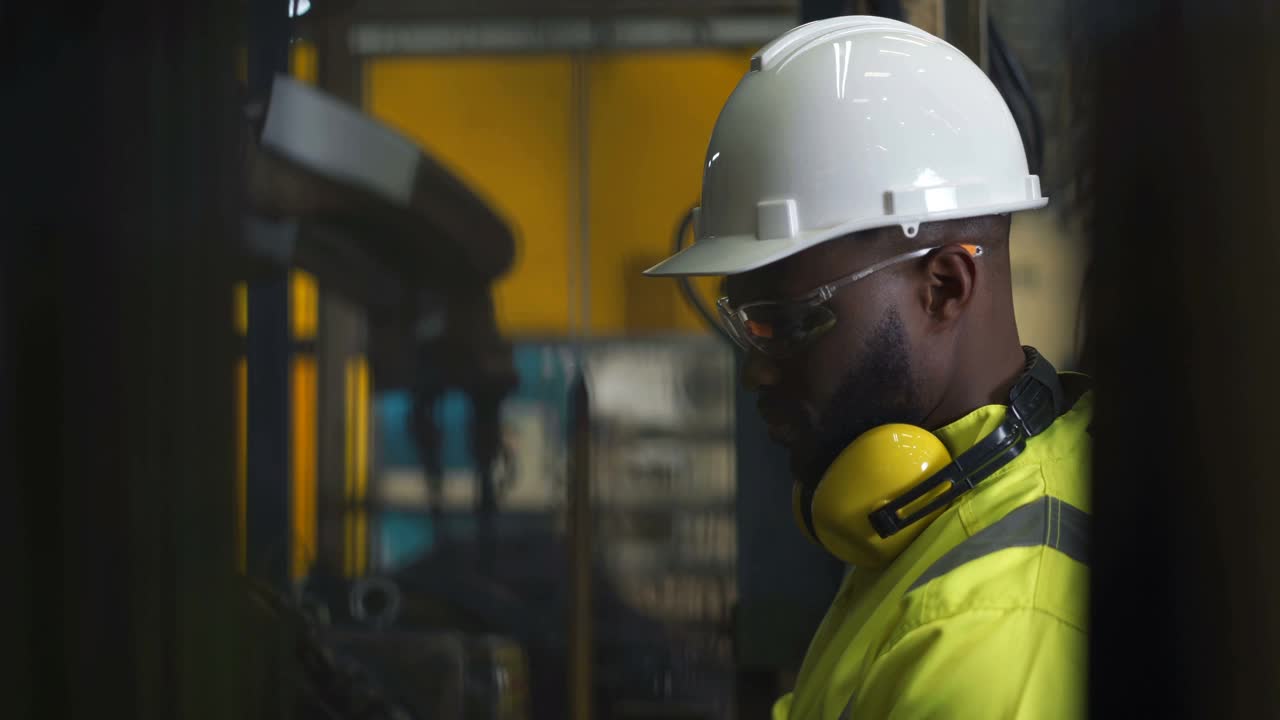 非洲黑人工程师在工业机器人上工作的特写视频素材