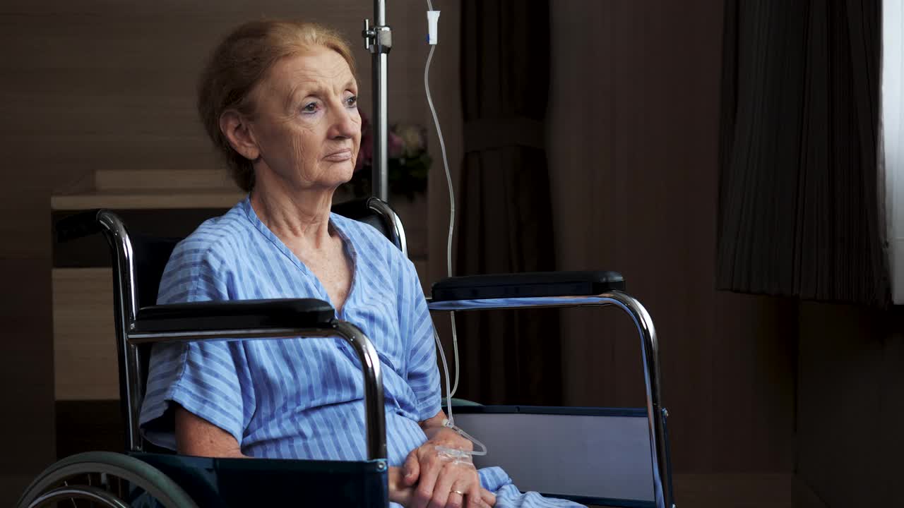 残疾老年妇女独自坐在轮椅上在医院。视频下载