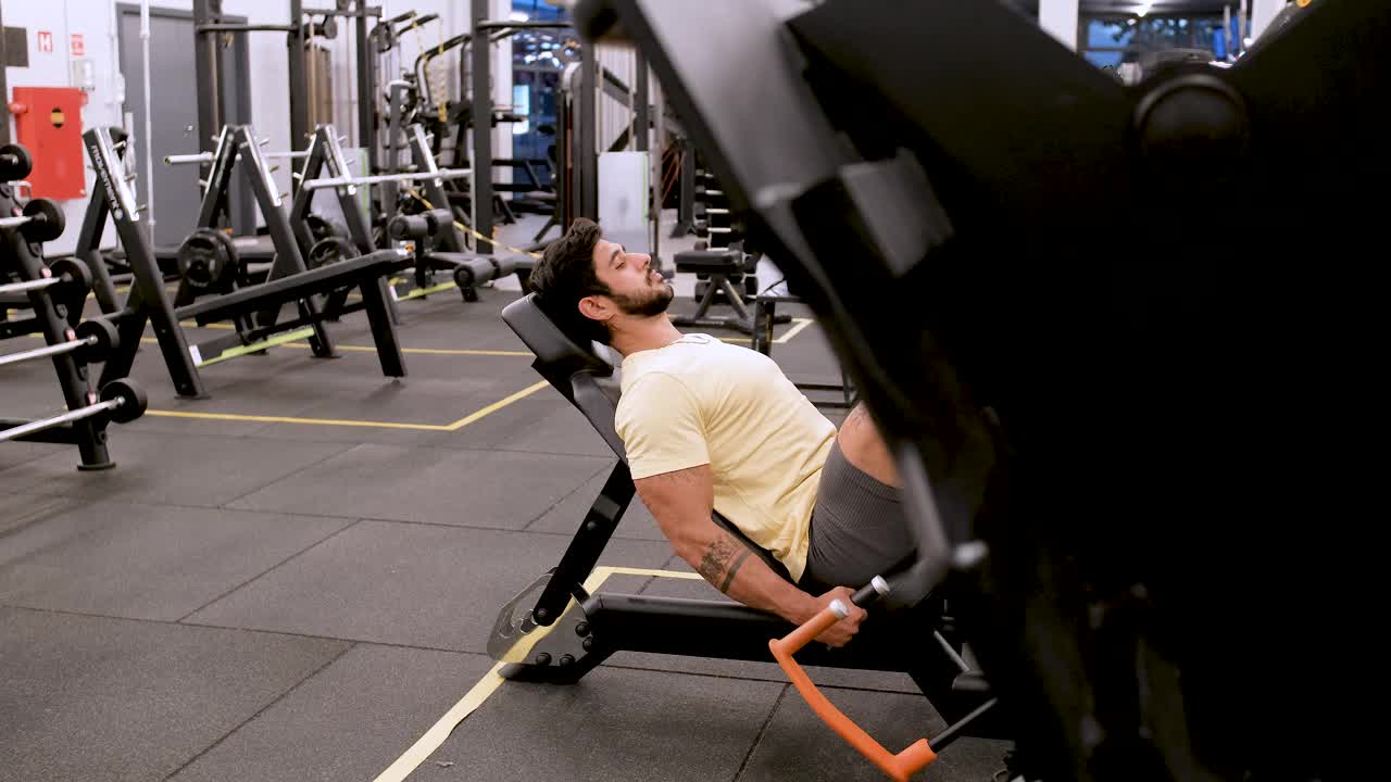 在健身房里用器械加强腿部力量的人视频素材