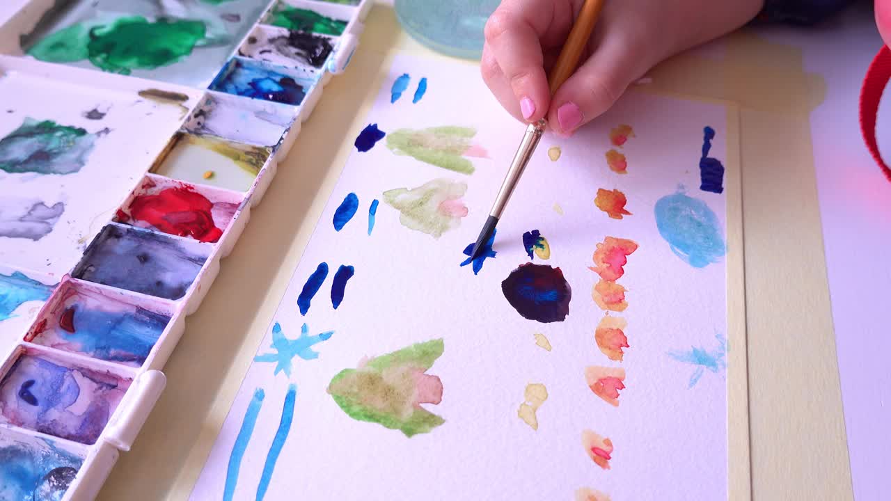 快乐的有创造力的年轻白种女孩在厚纸上用水彩画视频素材