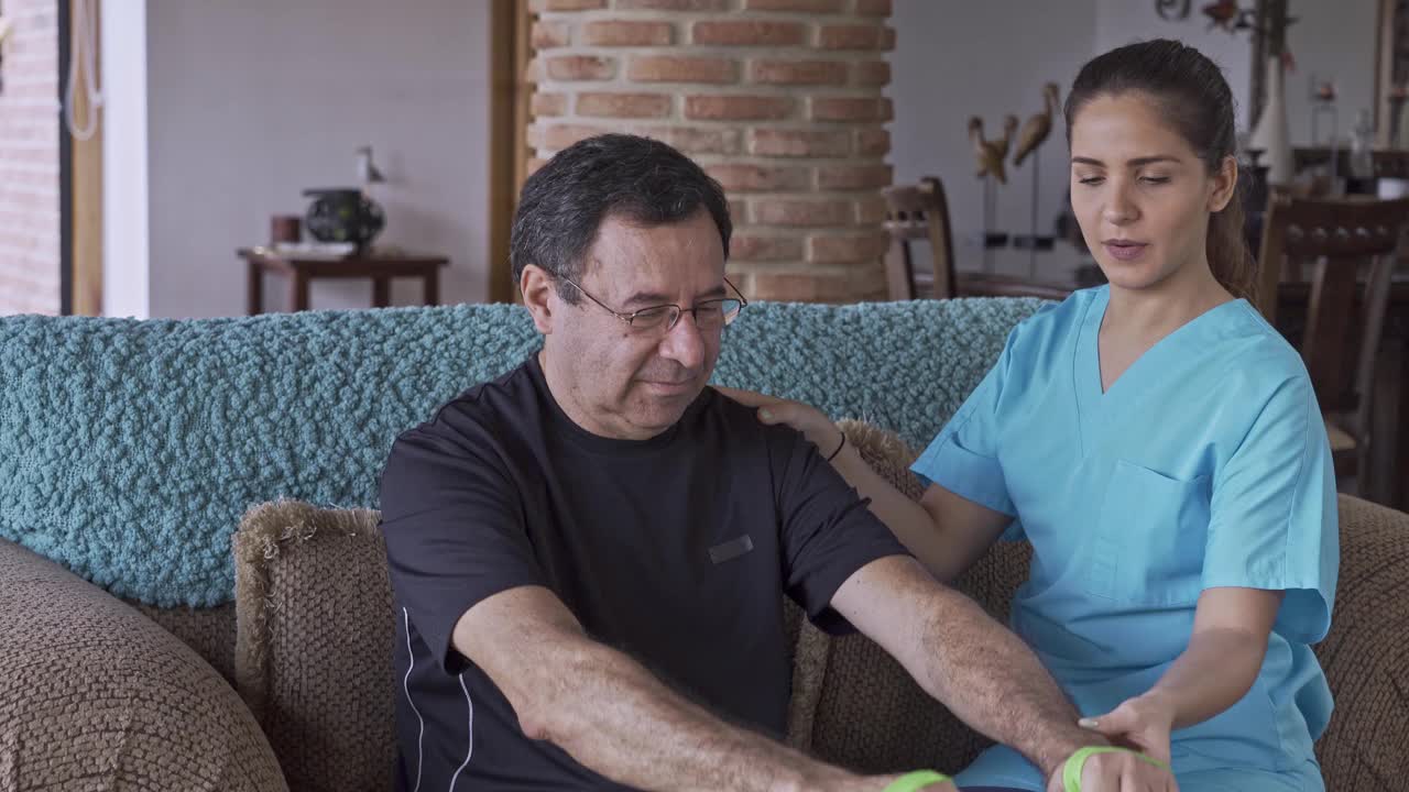 西班牙裔年轻治疗师帮助老年人改善家庭活动能力。视频下载