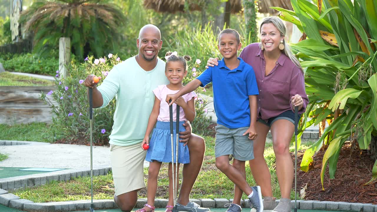 跨种族家庭，两个孩子在打迷你高尔夫视频下载