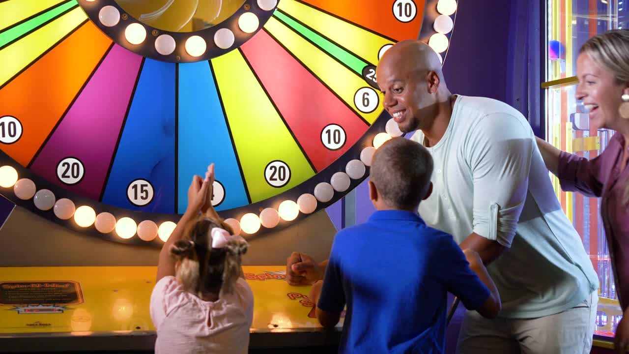跨种族家庭，两个孩子在玩街机游戏视频素材