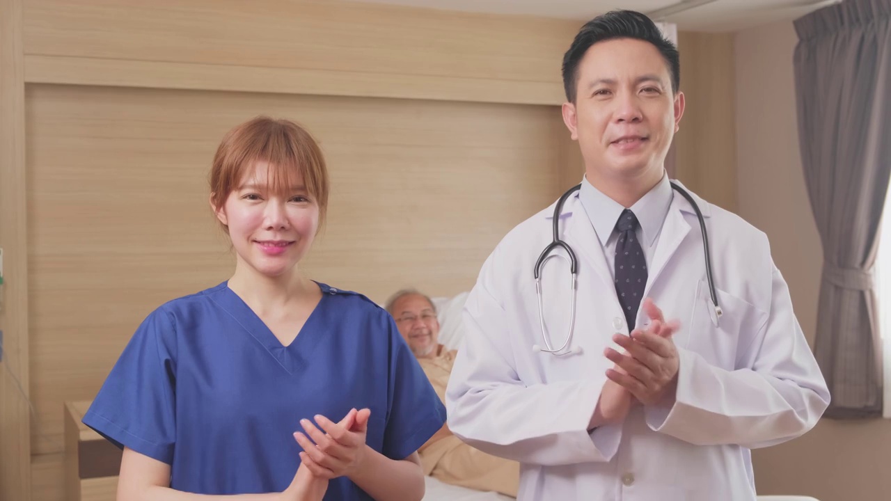 亚洲医生和护士微笑鼓掌鼓励病人的肖像。医疗队站在医院康复室的病床前。视频素材