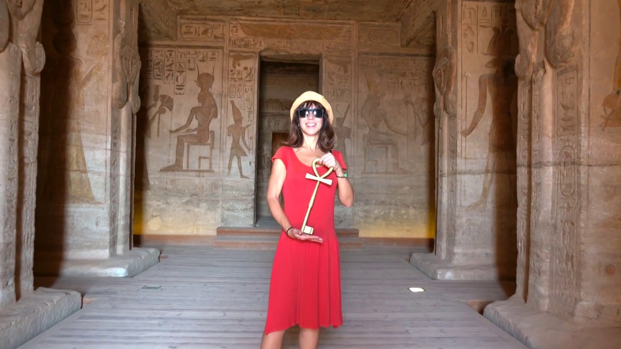 一个年轻的女人正在参观阿布辛贝神庙的内部装饰和珍贵的象形文字，在埃及南部的努比亚靠近纳赛尔湖。拉美西斯二世法老庙，4k视频视频下载
