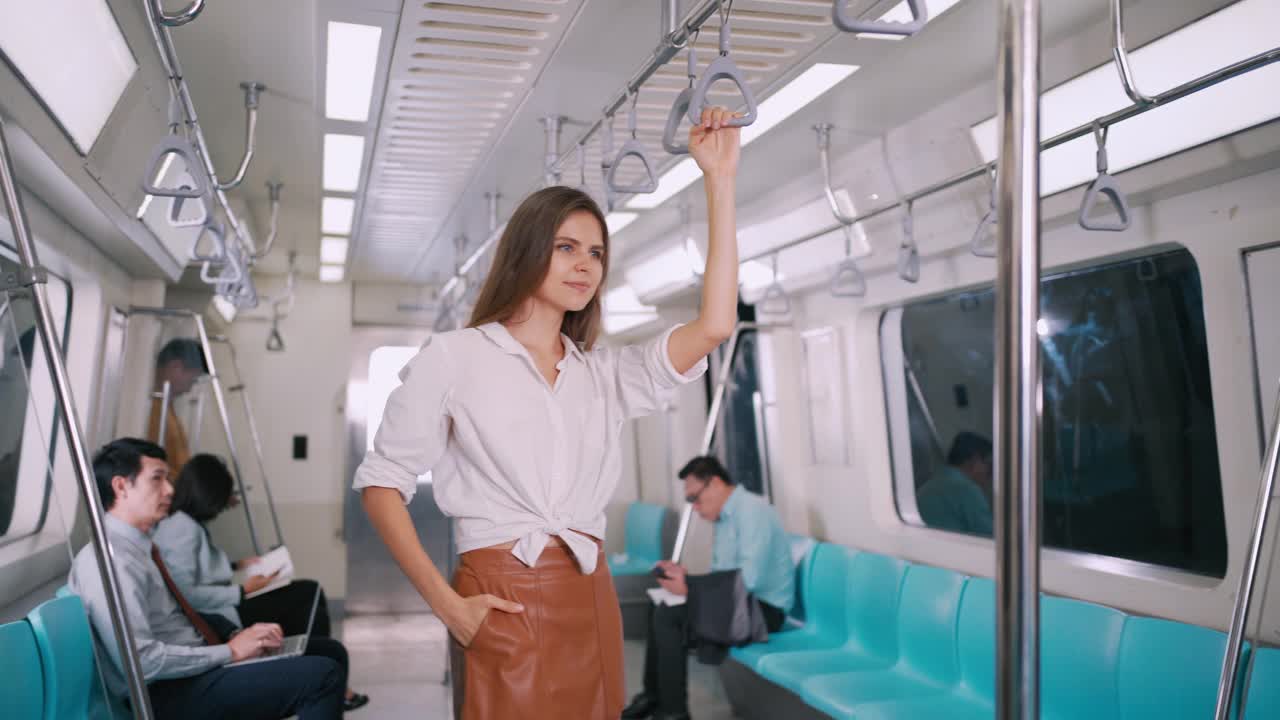 女商人站在轻轨或地铁上迎接朋友的商人在他们的工作运输人多元化的生活理念。视频下载