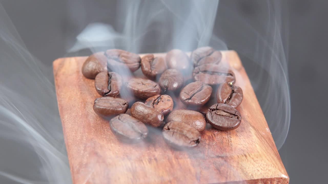 香浓的咖啡豆在热蒸汽近距离在黑暗的背景。芳香的咖啡视频下载