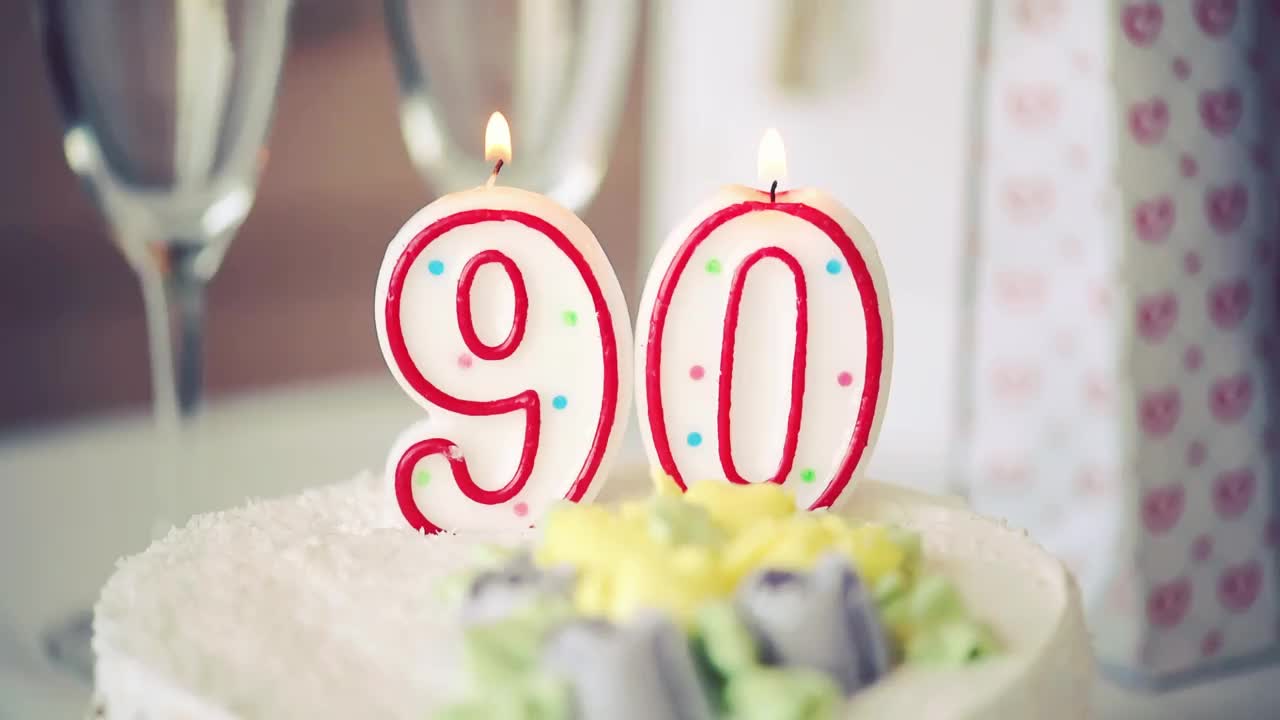 生日蜡烛作为90号90号在桌子上的甜蛋糕，90岁生日，调视频视频下载