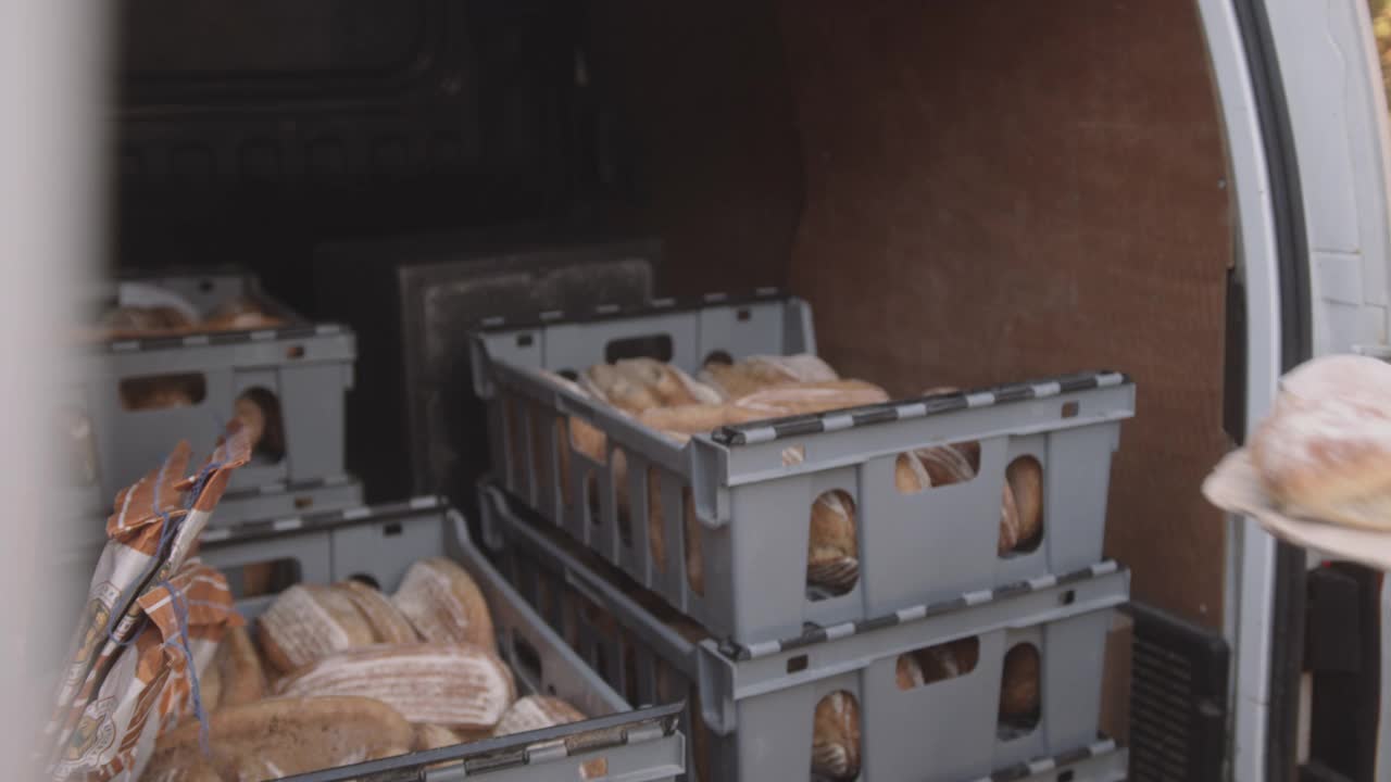 男面包师把新鲜出炉的夏巴塔面包放在送货车上视频素材
