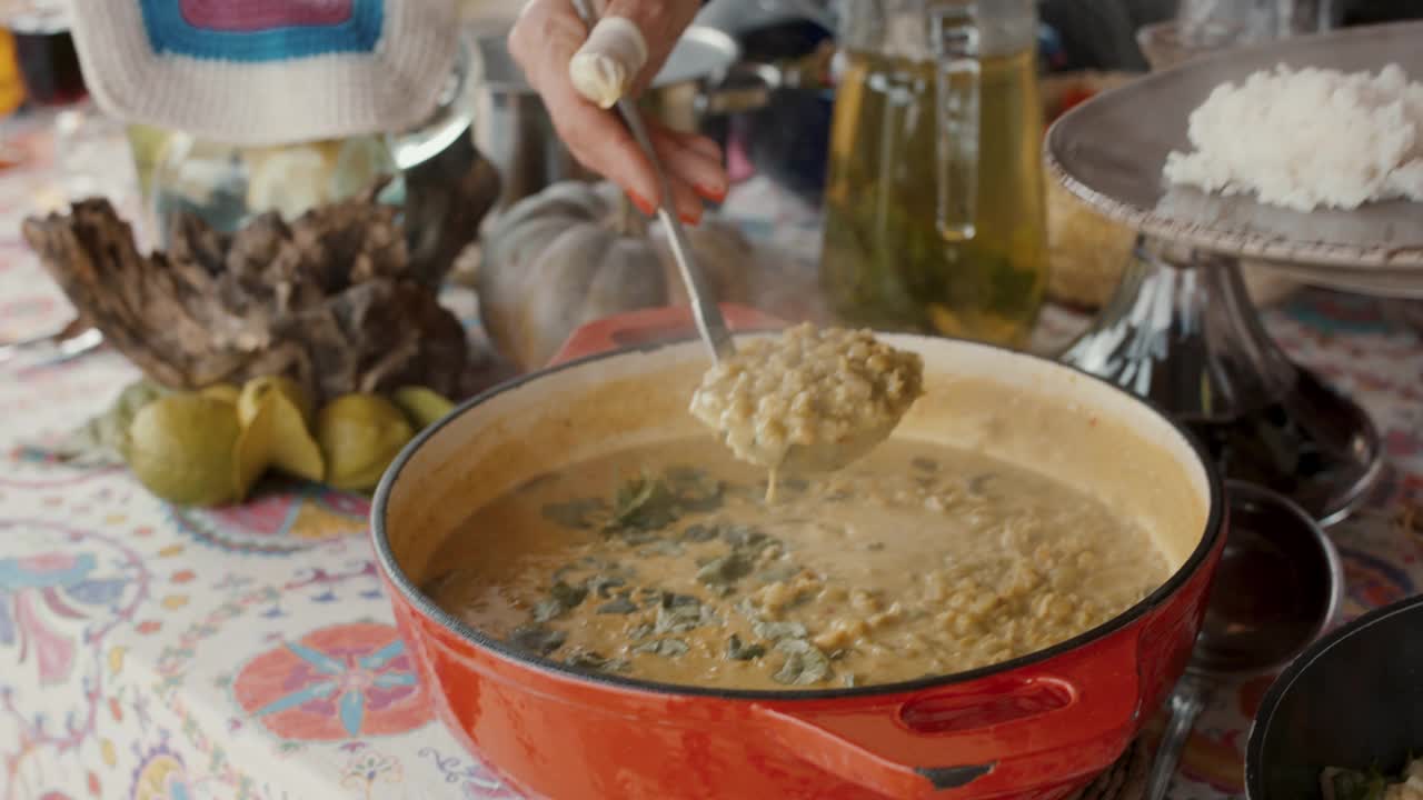 在家庭午餐上放咖喱扁豆的女人视频素材