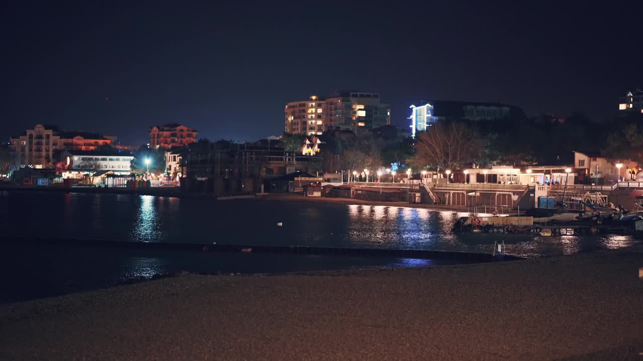 格伦齐克海滨度假胜地的海岸线在夜晚与照明现代建筑的背景反射在海面上视频素材