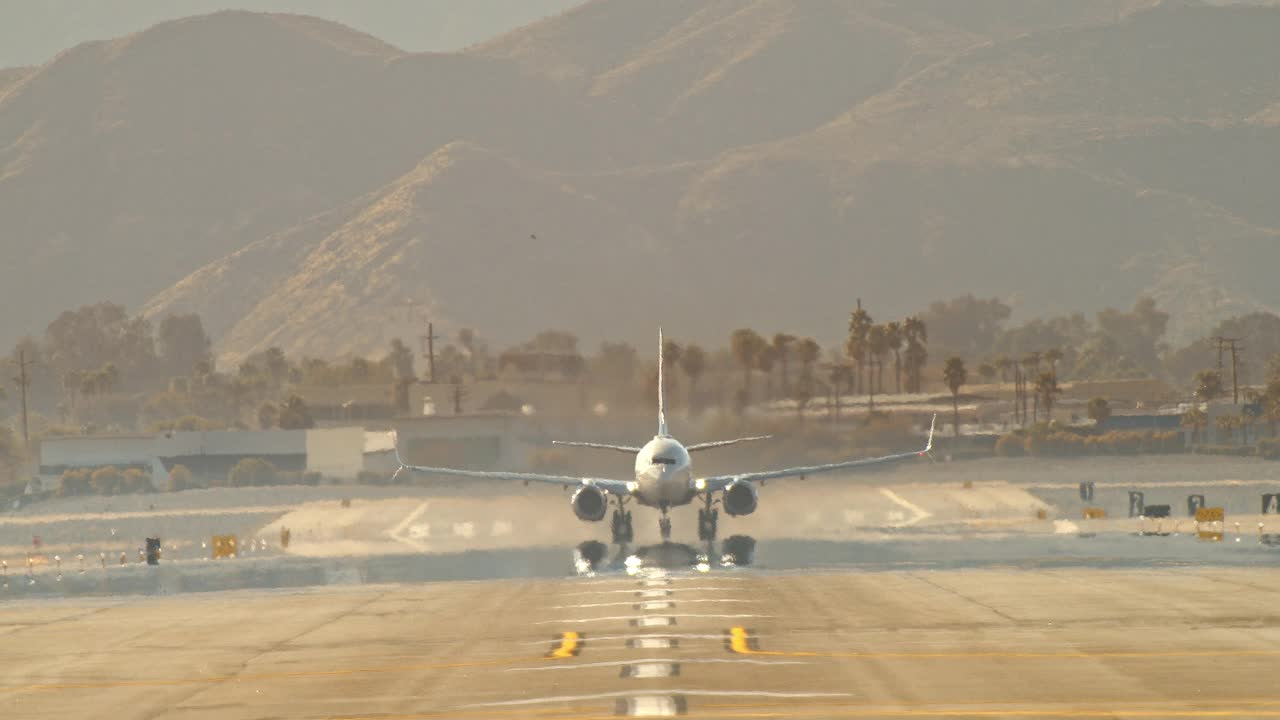 WS极端长镜头视角的达美航空客机起飞从机场跑道扭曲缓慢移动的热浪产生的炎热气候视频素材