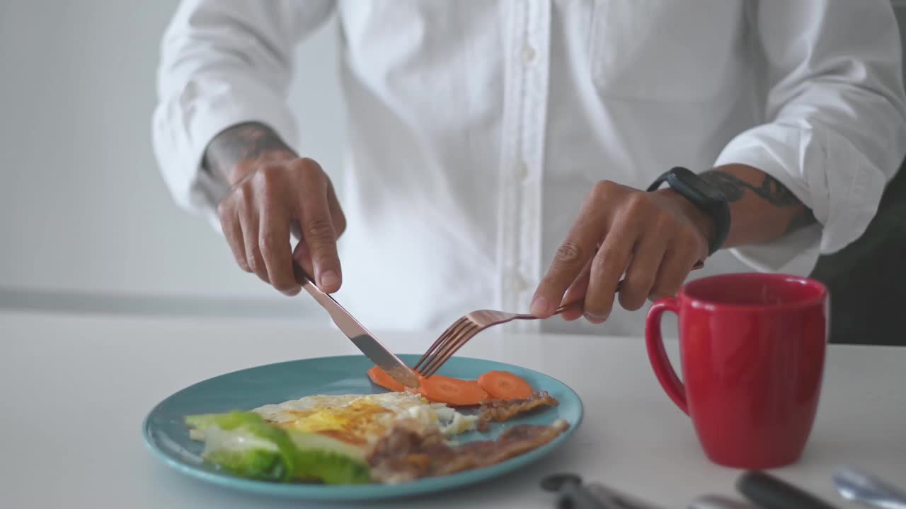 亚洲华人高级男子手享受他的早餐在厨房柜台视频素材