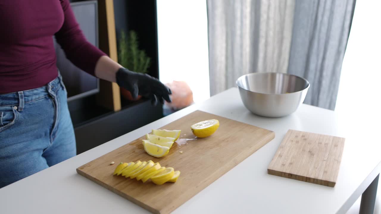 一位年轻女子在家里的切菜板上切柠檬视频素材