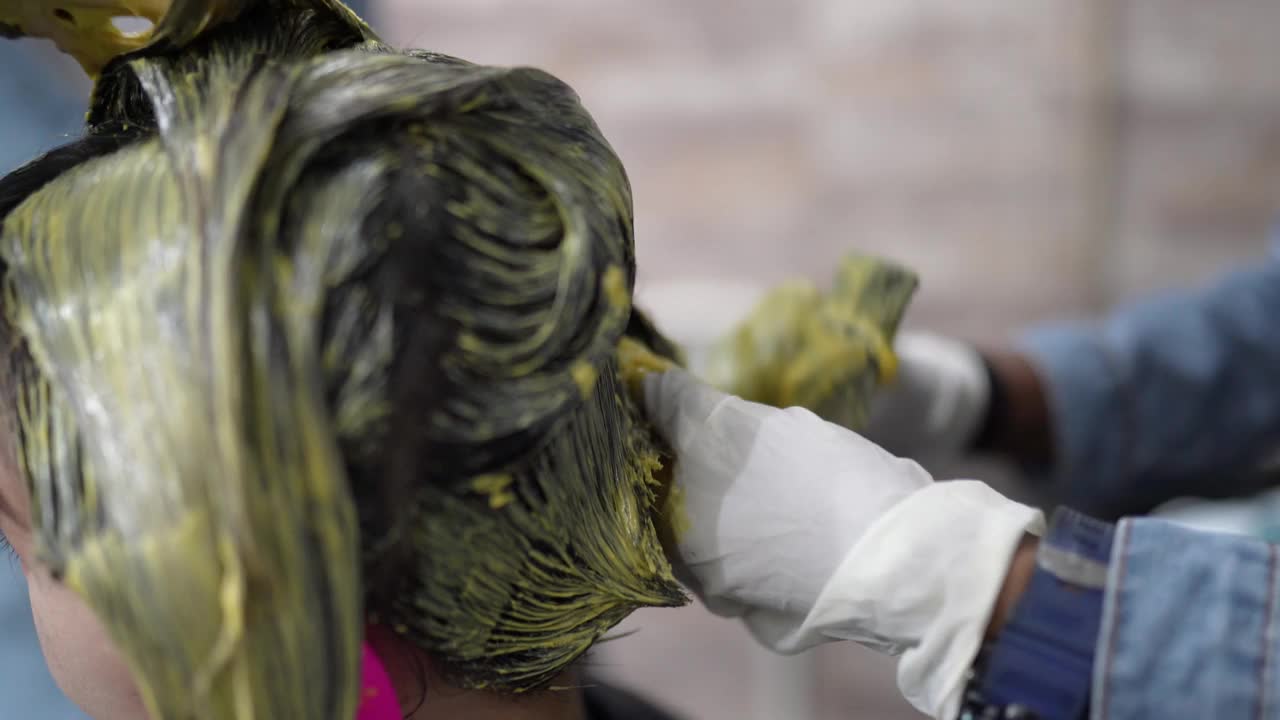 近距离观看亚洲华裔美女在美容院染发。视频下载