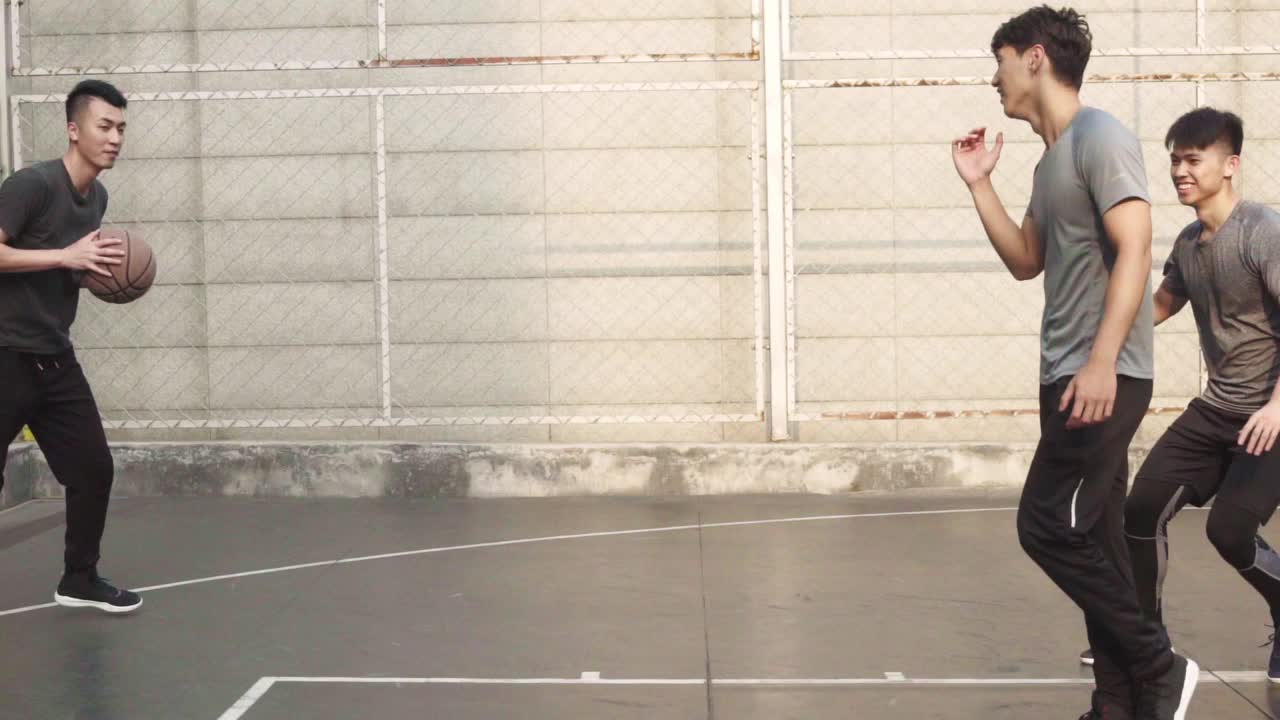 年轻的亚洲男子在户外打篮球视频素材