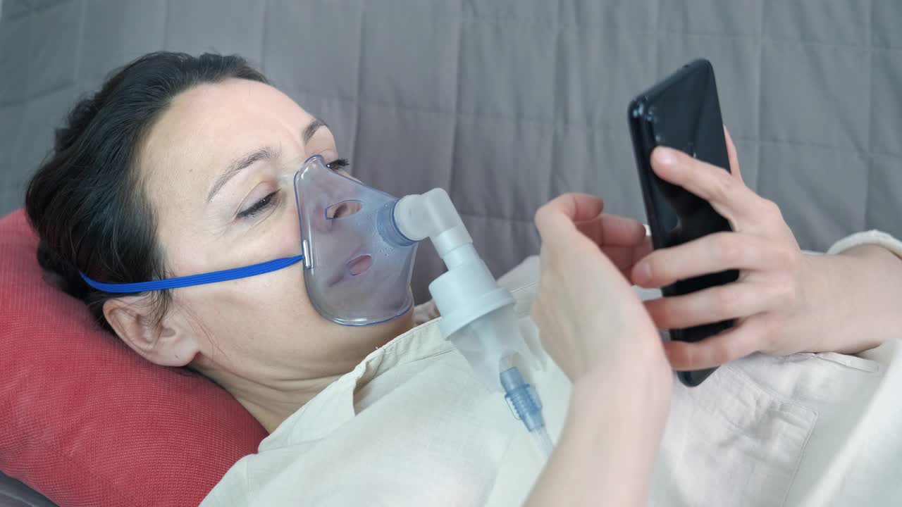 一个带着吸入器和智能手机的女性。视频素材