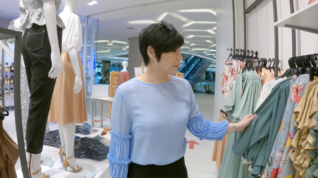优雅的亚洲华人女性在服装店购物视频下载