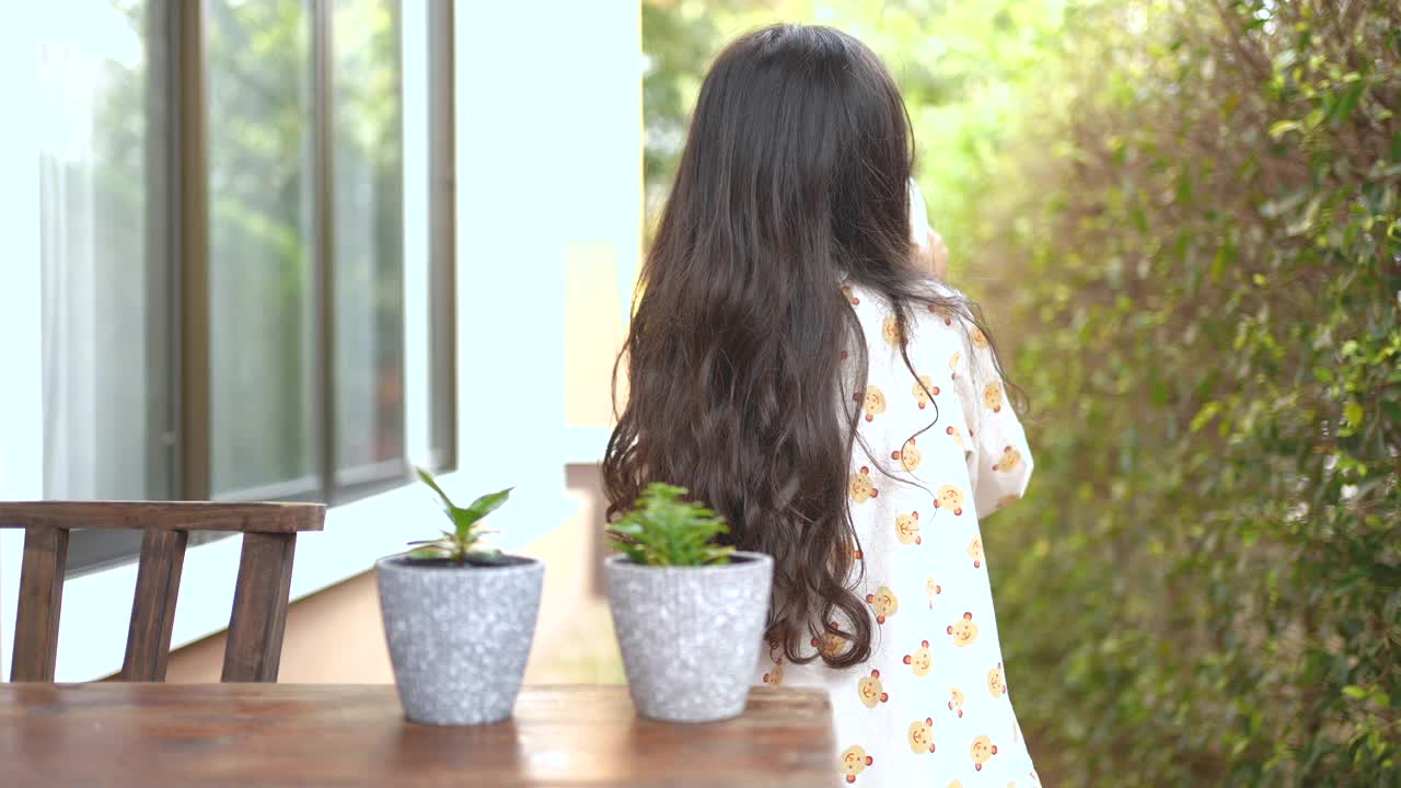 小女孩在早上给一株小植物浇水视频素材