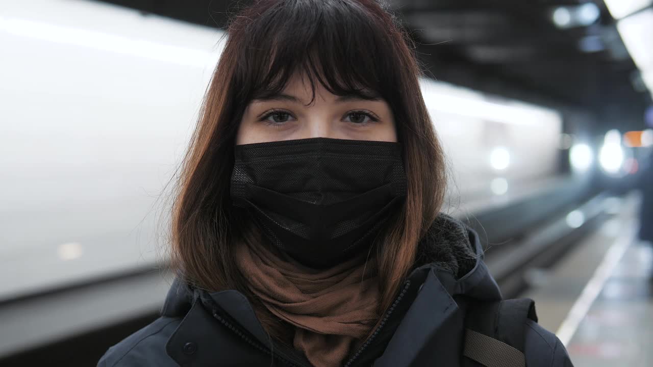 戴面具的女子在地铁站候车视频素材